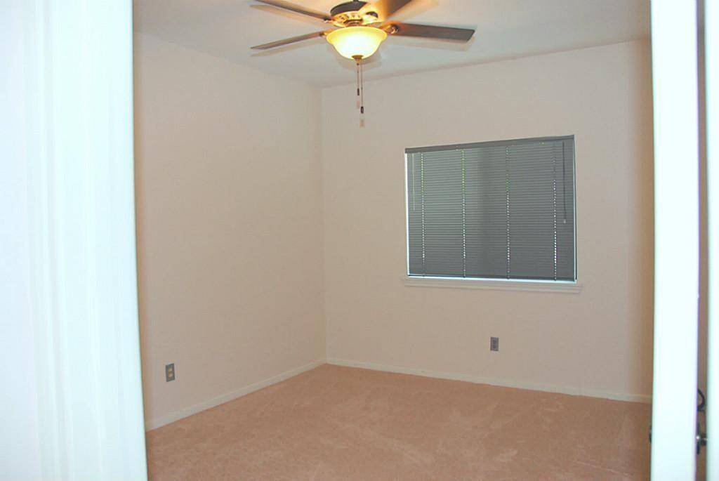 Bedroom 2 of 3 with carpeting and ceiling fan.