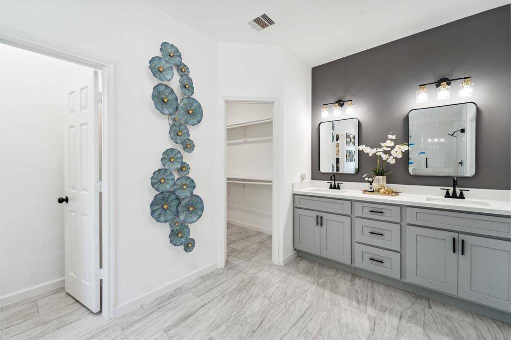 brand new primary bathroom with double vanity sinks, new plumbing and light fixtures