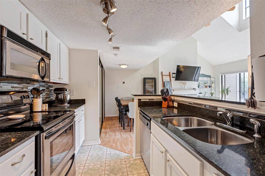 View from the kitchen showcasing the dining area and stylish cupboard with sleek mirror-like doors.