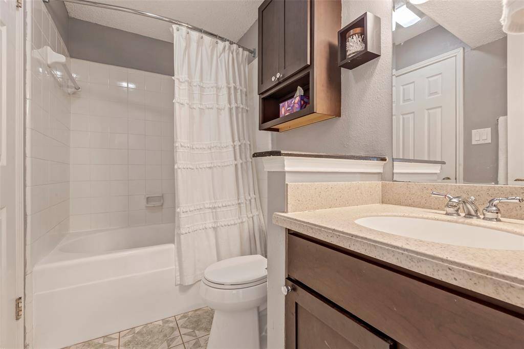 Bathroom featuring a tub and shower combo, complemented by a single sink for your convenience.