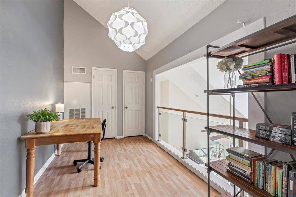 Overlooking the expansive living room below, this second-floor office features a balcony design that enhances the home's open and airy feel.