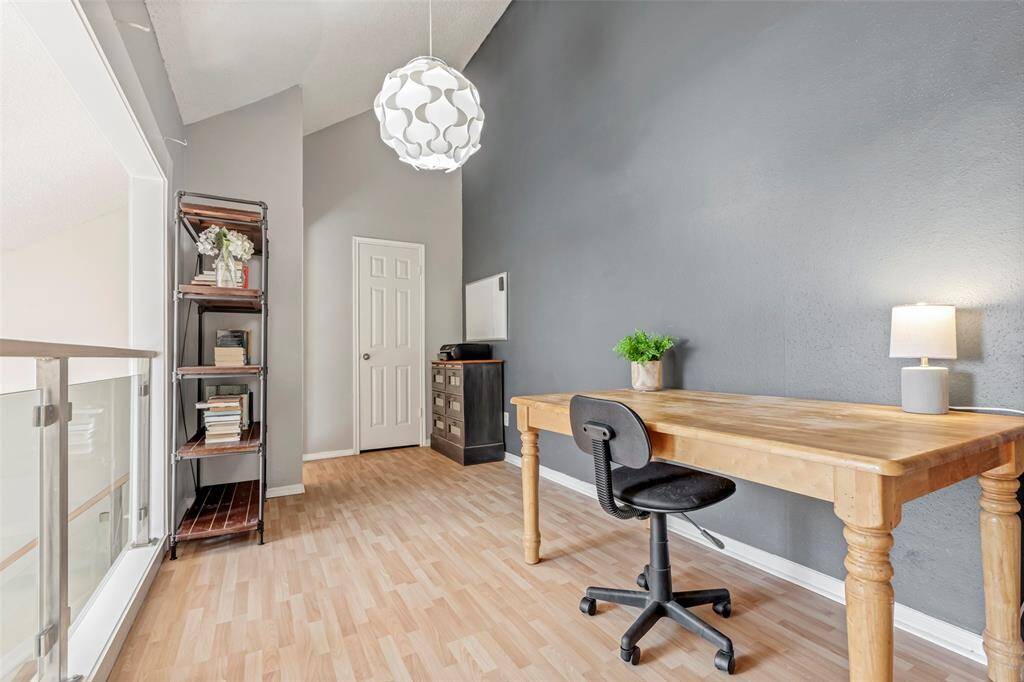 This second-floor office overlooks the living room below and features a walk-in closet at the end of the room, providing ample storage space.