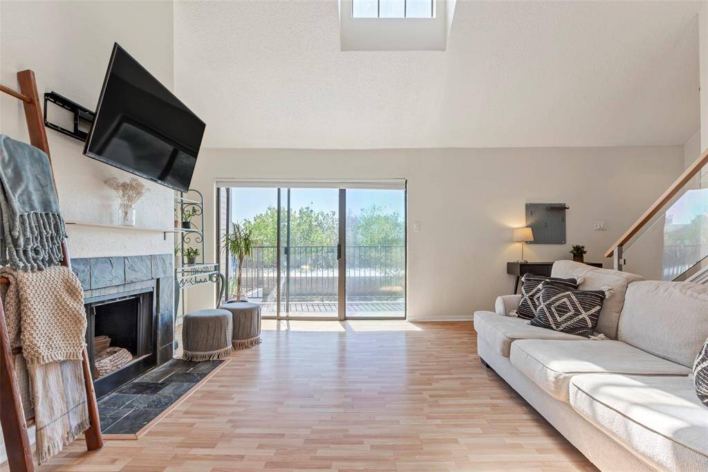 Inviting living room with a charming fireplace and glass sliding doors leading to the front patio.