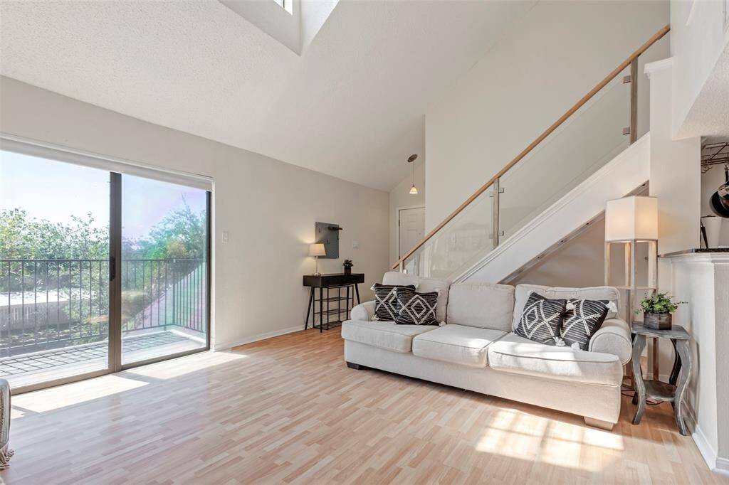 Additional view of the bright and airy living room with sleek laminate floors throughout.