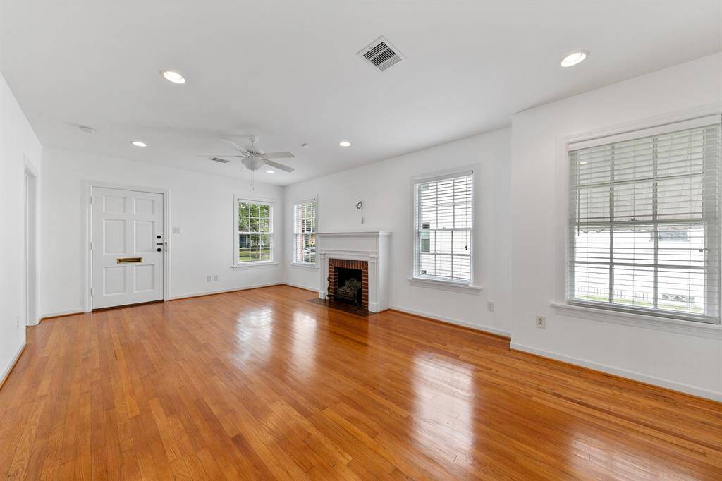 While the fireplace is decorative only, it adds ideal charm to this large living & dining area, full of windows offering natural light.