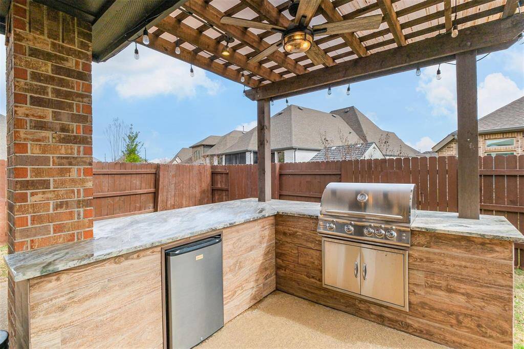 Covered Outdoor Kitchen withbuilt-in grill and fridge.