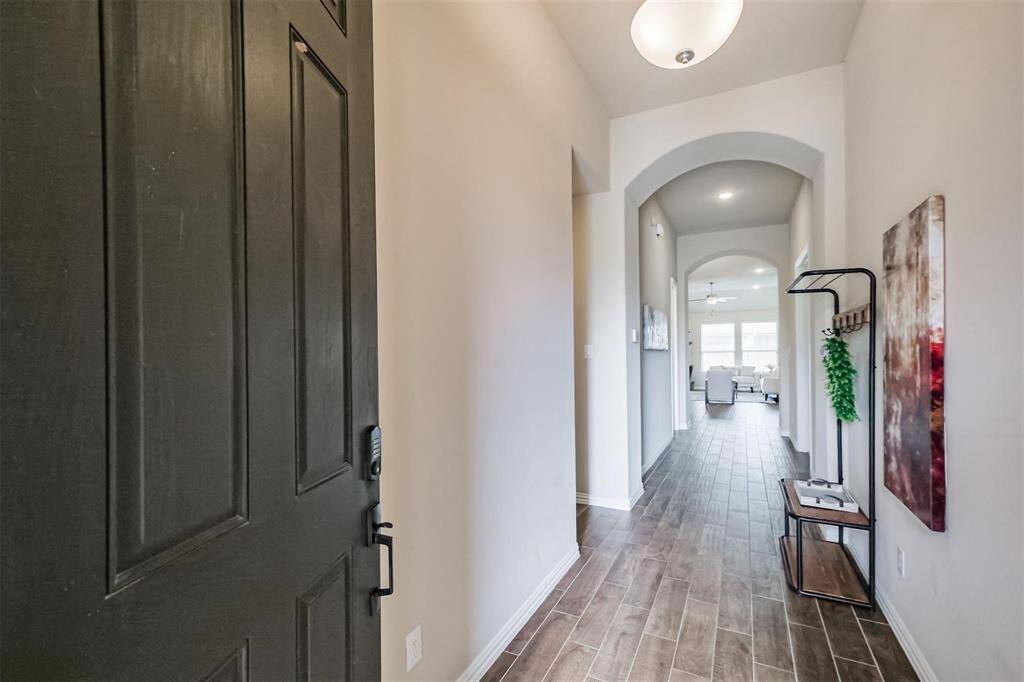 Stately entrance with tall ceilingsand wood-looking tile flooring.