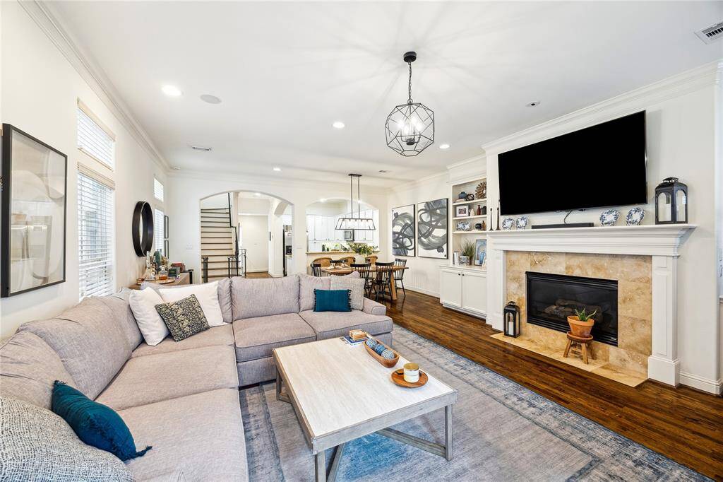 The living room has a gas log fireplace and built-in cabinets and shelving.