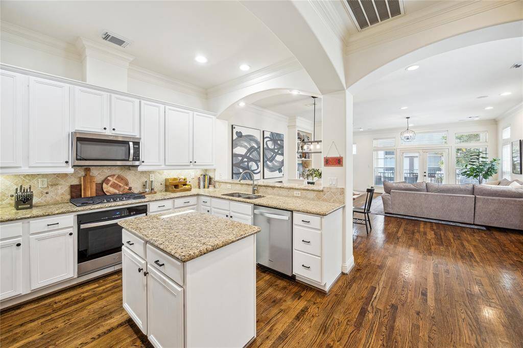 The kitchen is open to the dining area and the living room and has beautiful hardwood flooring.