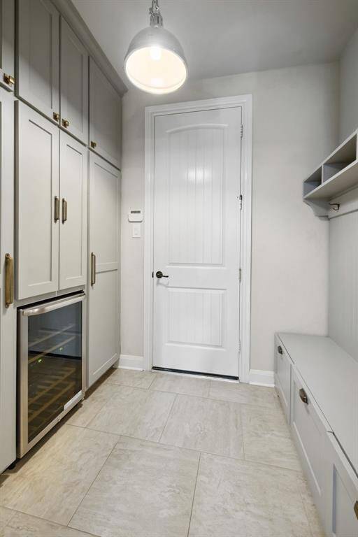 Mudroom to the garage with additional storage and wine fridge