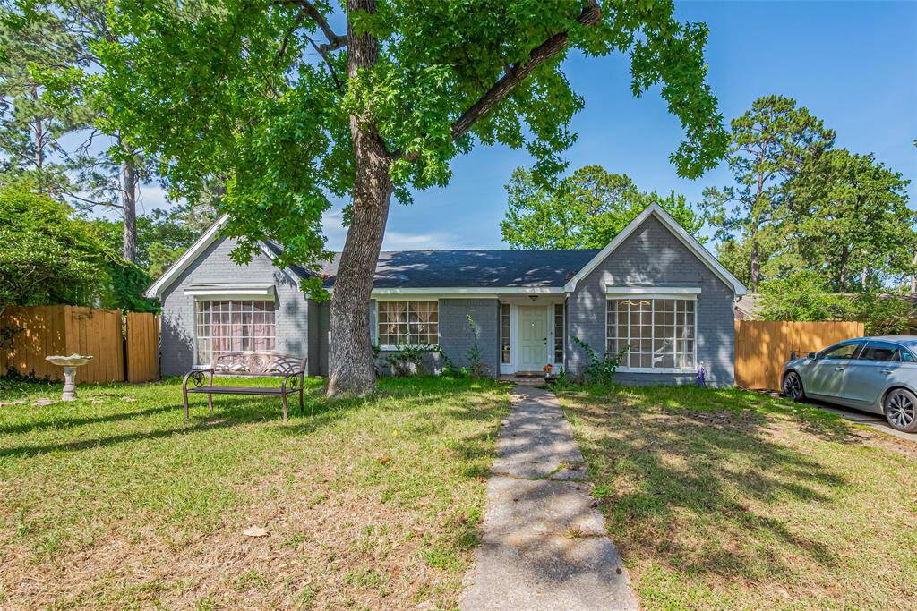 Charming ranch-style home with a tall shade tree out front.
