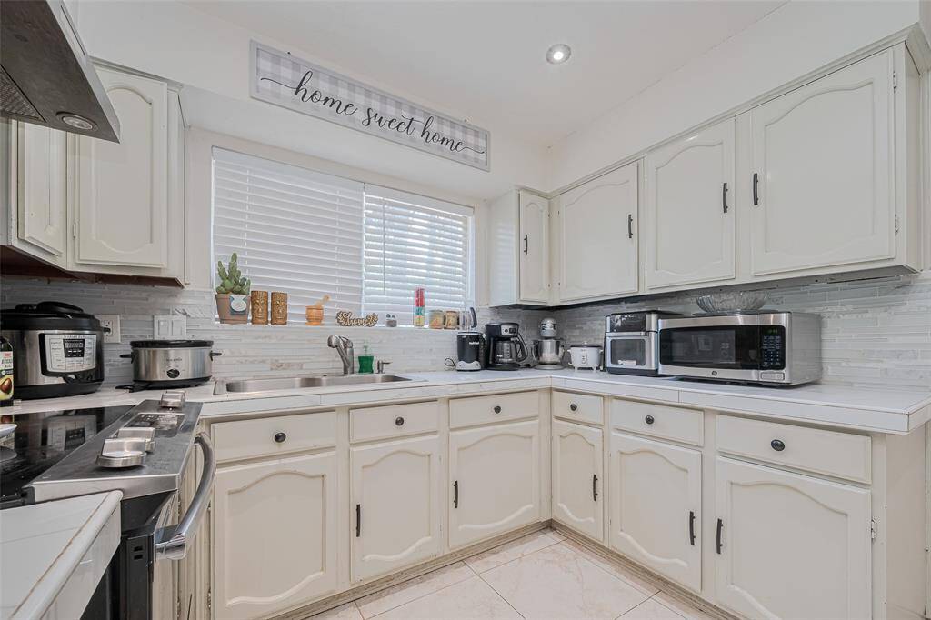 Kitchen with tiled flooring and recessed lighting.