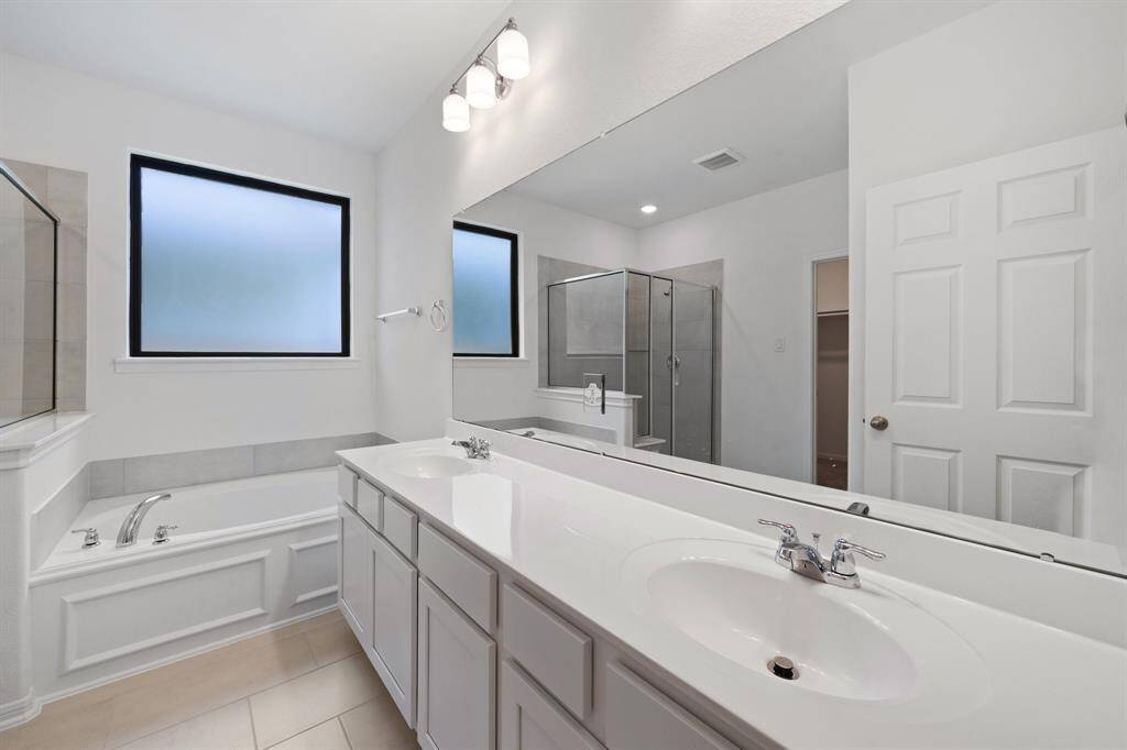 The en-suite bathroom offers a spa-like atmosphere with its elegant design, high end finishes, and tasteful lighting, creating a retreat within your own home.
