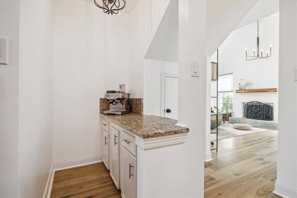 This area features a granite countertop and white cabinets and opens up to a bright living area. . It would be perfect for a coffee station or even a dry bar