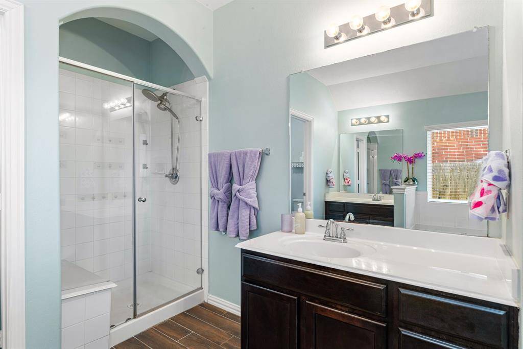 This additional view of the primary bath showcases a walk-in shower with tile surround.