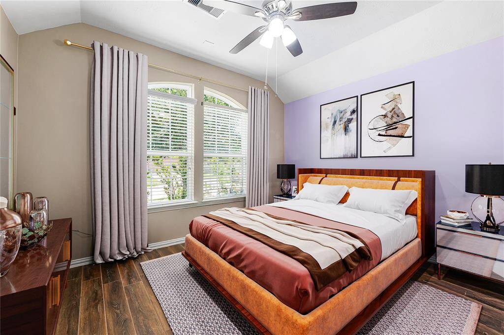 Secondary bedroom great for use as an in-law suite or guest suite features high ceilings, lovely modern ceiling fan, custom paint, wood stlye flooring, direct access to the secondary bathroom and large window with privacy blinds. *Virtually Staged