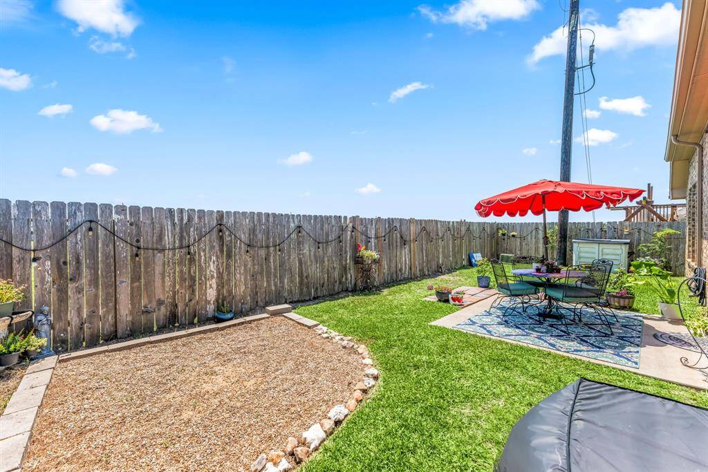 Spacious backyard features a charming gravel area and a fully fenced perimeter, offering privacy and endless possibilities for customization.