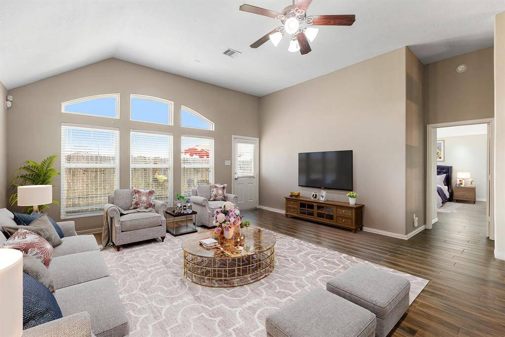 This light and bright spacious living room is the perfect layout for entertaining or just relaxing. Whether it's simply a night in or entertaining family and friends, this home has ample open space for everyone to enjoy! Featuring dark stained ceiling fan, wood style flooring, large windows with blinds, soaring high ceilings, with wonderful access to your gorgeous kitchen. *Virtually Staged