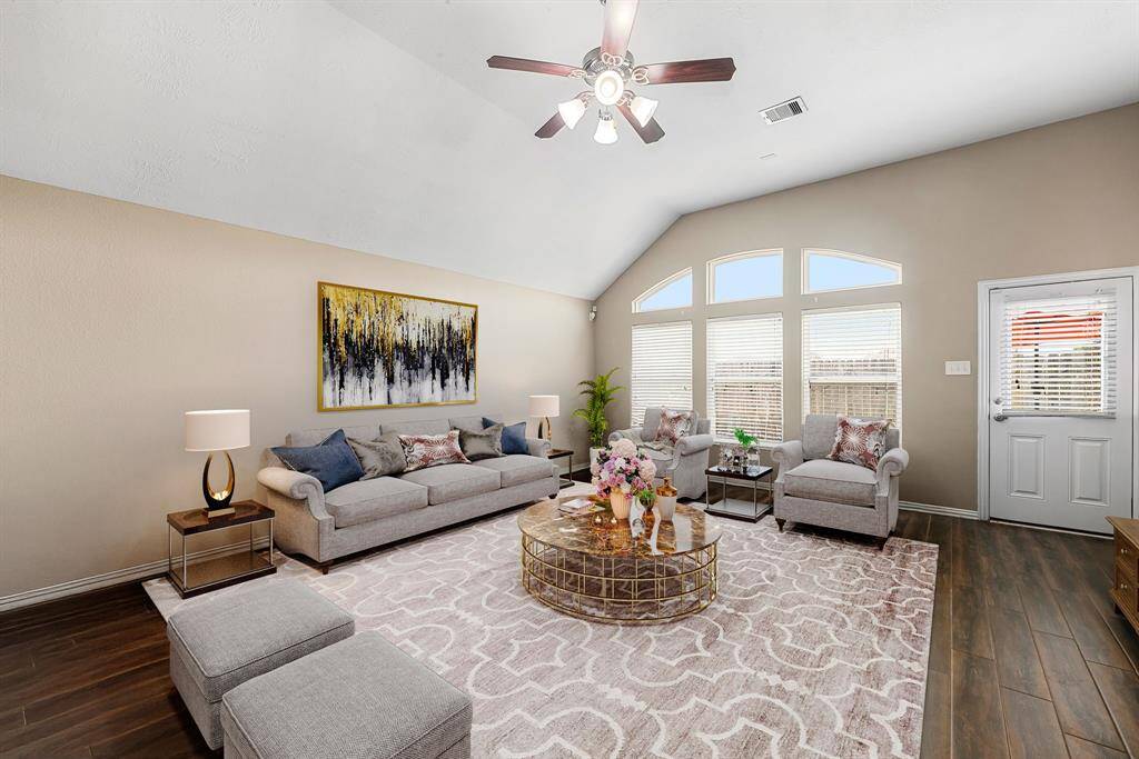 This light and bright spacious living room is the perfect layout for entertaining or just relaxing. Whether it's simply a night in or entertaining family and friends, this home has ample open space for everyone to enjoy! Featuring dark stained ceiling fan, wood style flooring, large windows with blinds, high ceilings, and wonderful access to your gorgeous kitchen. *Virtually Staged