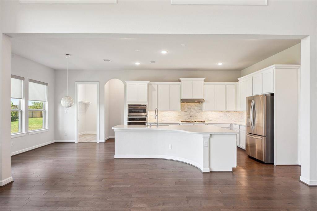 This stunning kitchen blends warmth and sophistication with elegant maple cabinets and a seamless custom fridge surround for a polished, built-in look. At its center, a spacious island provides ample space for meal prep, casual dining, and lively gatherings—making it the true heart of the home. Designed for both grand celebrations and everyday family dinners, it offers the perfect blend of style and functionality featuring an upgraded 36" cooktop, dual built-in wall oven and convection microwave.