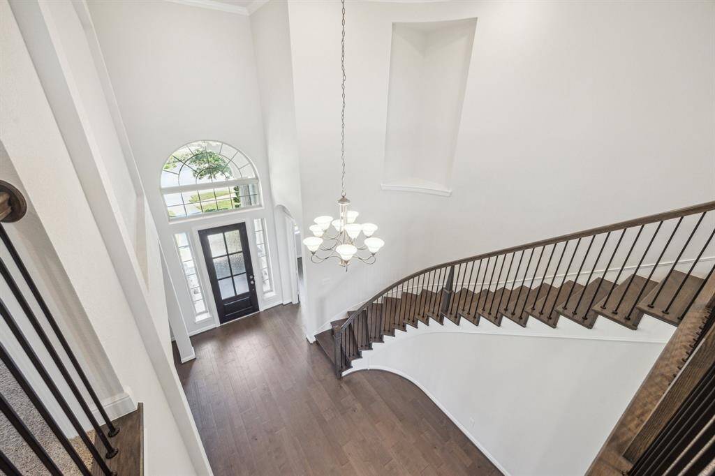 A peak from the open landing on the second floor showcases dramatic views of the foyer below and the beautiful full oak curve stairway.