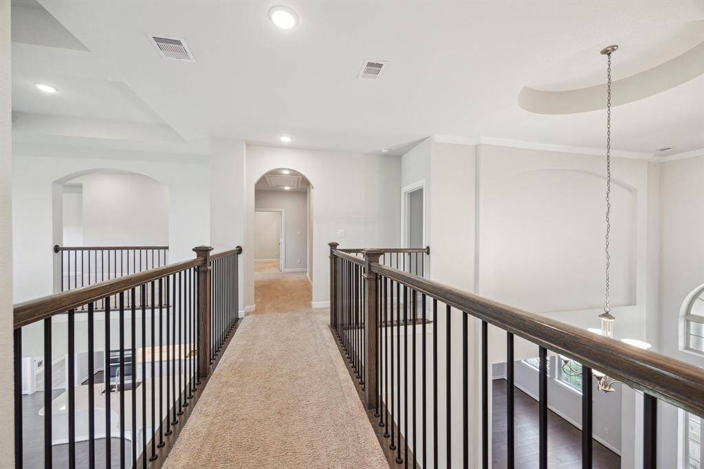 This well-designed second-floor open landing /hallway offers a seamless connection to the home's living spaces, creating an open and accessible layout. With its thoughtful placement, it ensures effortless movement between rooms while providing a beautiful vantage point overlooking the main living area and foyer. Whether heading to the game room, bedrooms, or additional gathering spaces, this hallway enhances the home's flow, making navigation both convenient and visually striking.