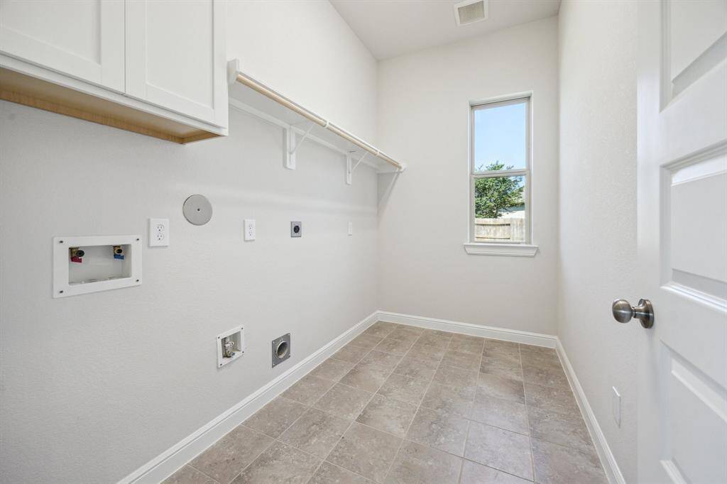 This spacious utility room is thoughtfully situated on the first floor, offering easy access while maintaining privacy. Tucked away for a seamless blend of functionality and discretion, it provides the perfect space for laundry, storage, and household tasks without disrupting the home's flow. Whether organizing essentials or tackling daily chores, this well-placed utility room is designed to enhance convenience while keeping things neatly out of sight.