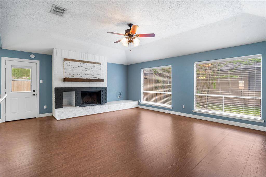 Floor to ceiling windows offers natural light to pour into the living room, charming wood burning fireplace