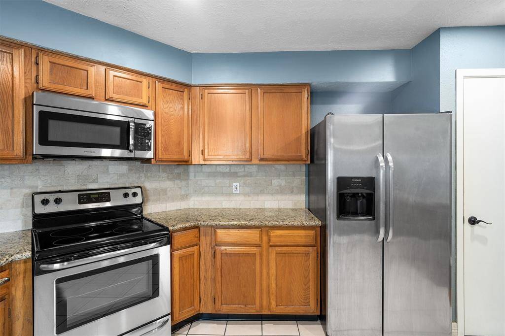Kitchen featuring stainless steel appliances, granite countertops and plenty of storage!