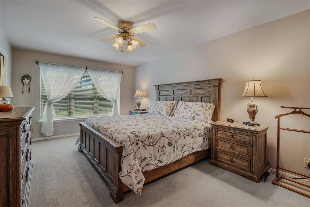 Primary bedroom has plenty of space for large furniture. It also has carpet, ceiling fan and large picture windows.