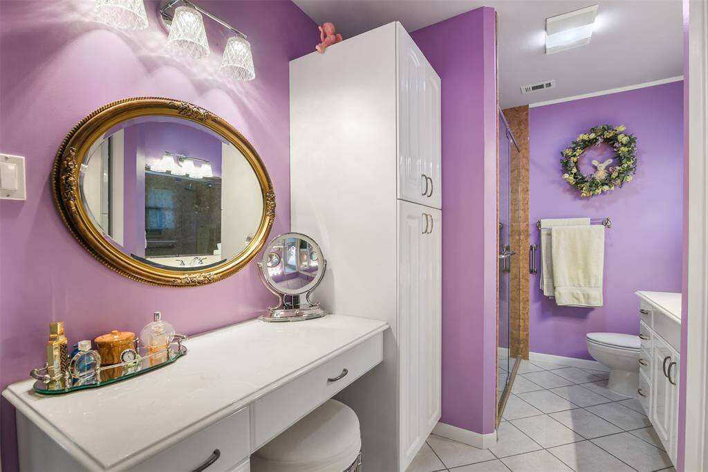 Primary bathroom has built in vanity area with storage.