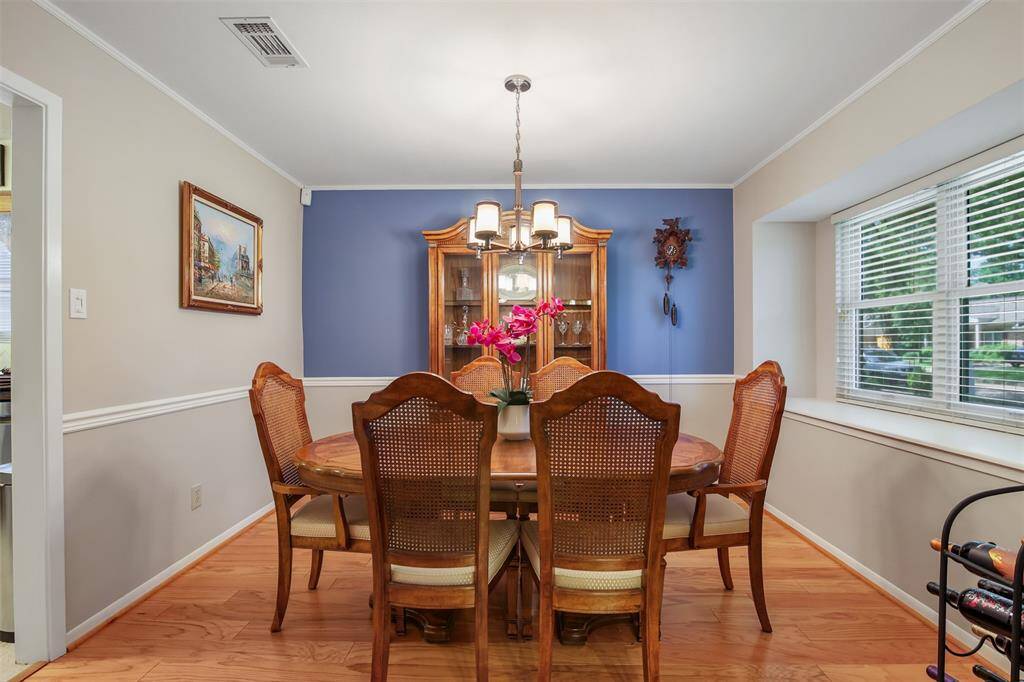 The dining room has the continued engineered wood floors, crown molding and chair rail.