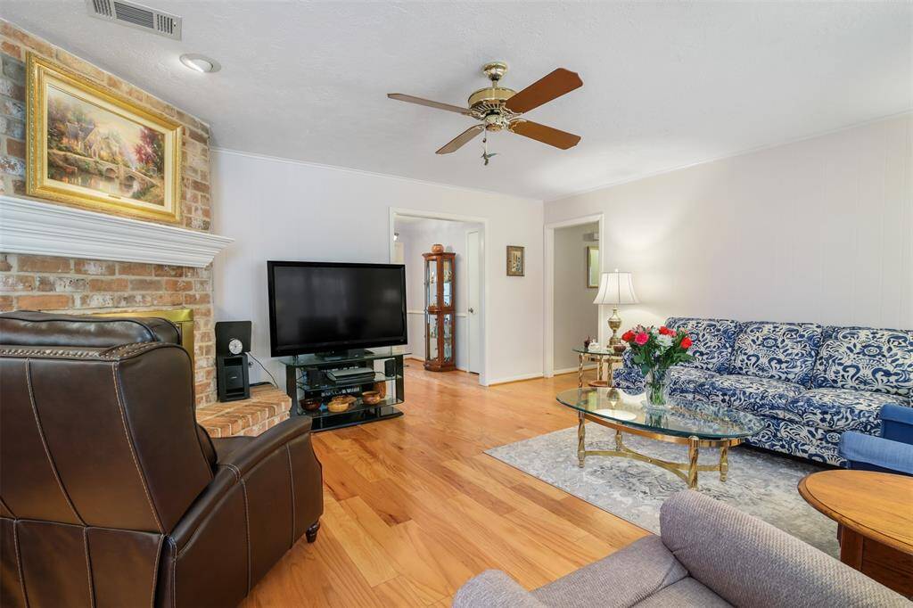 Spacious family room is the heart of the home. It features engineered wood floors, ceiling fan and access to the hallway leading to the bedrooms.