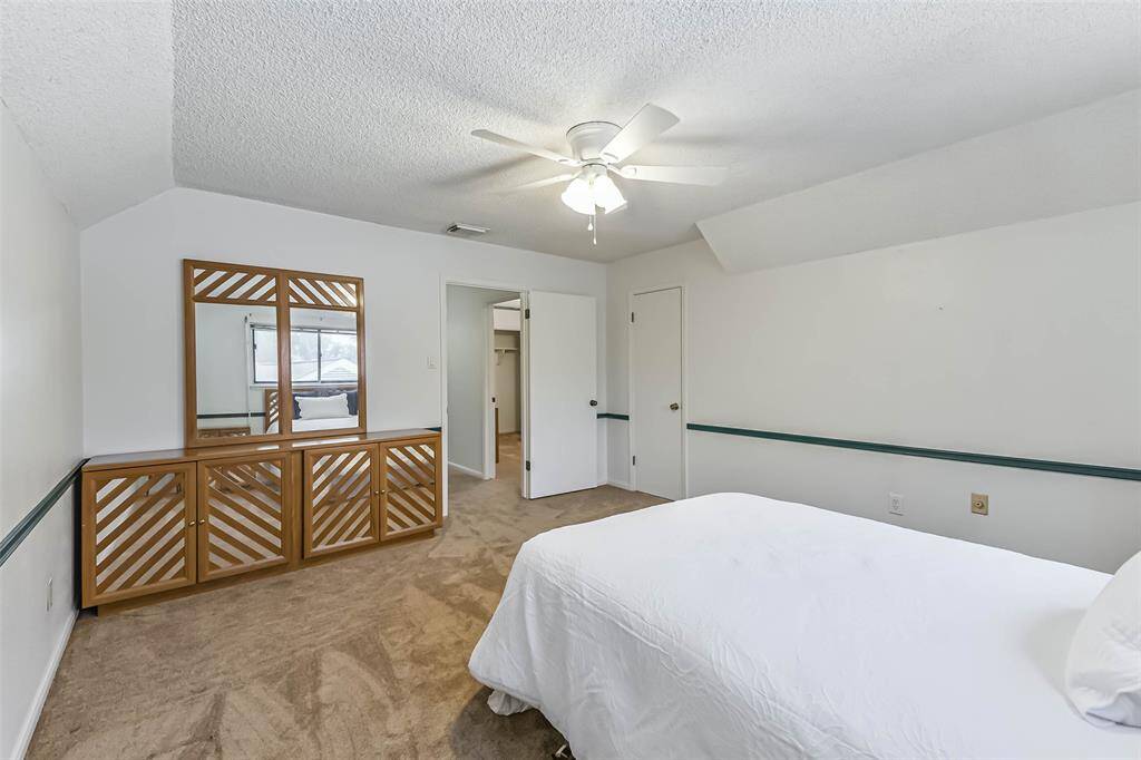 secondary bedroom at top of stairs with walk-in closet