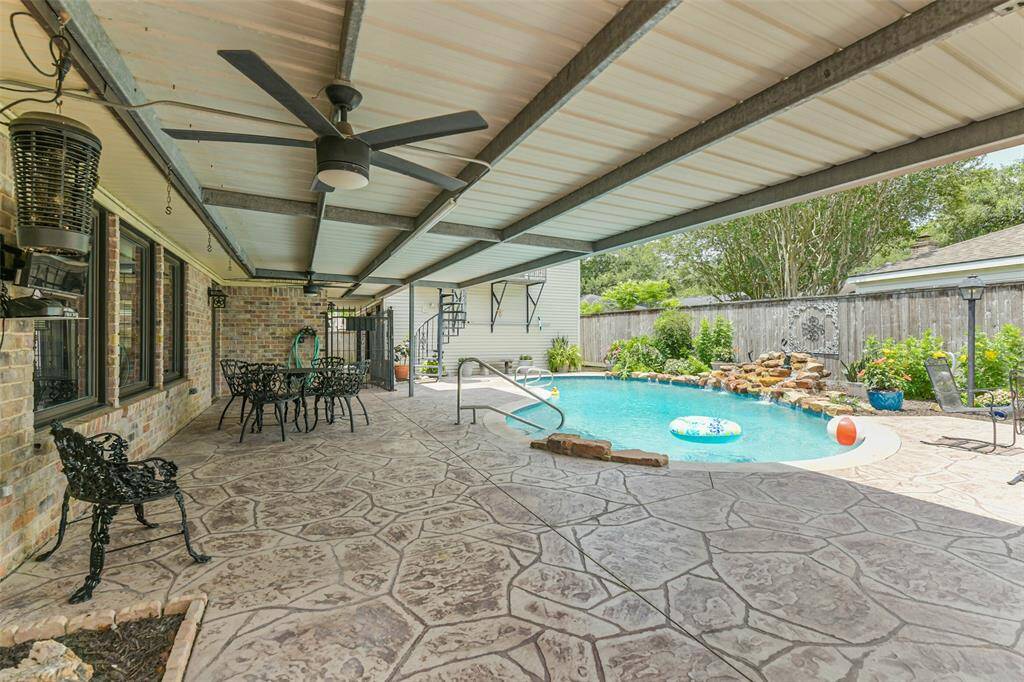 covered back patio with breeze way to garage and stairs to gameroom above garage