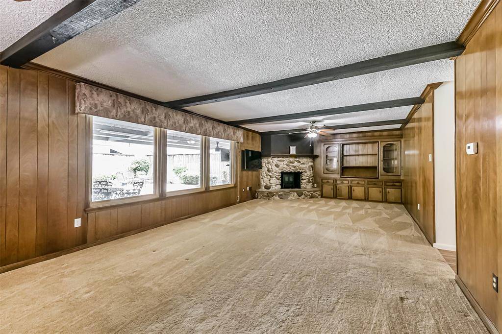view into living room with gas fireplace and built-ins