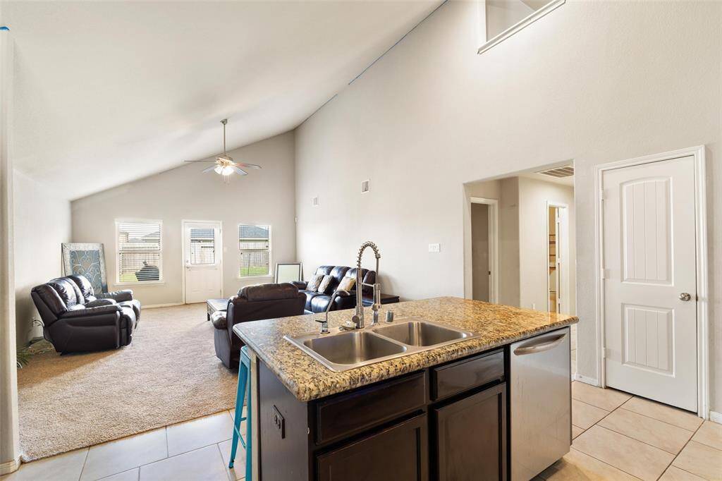 The granite island includes a dual sink, stainless steel dishwasher, and bar seating. Oerfect for entertaining or everyday functionality.