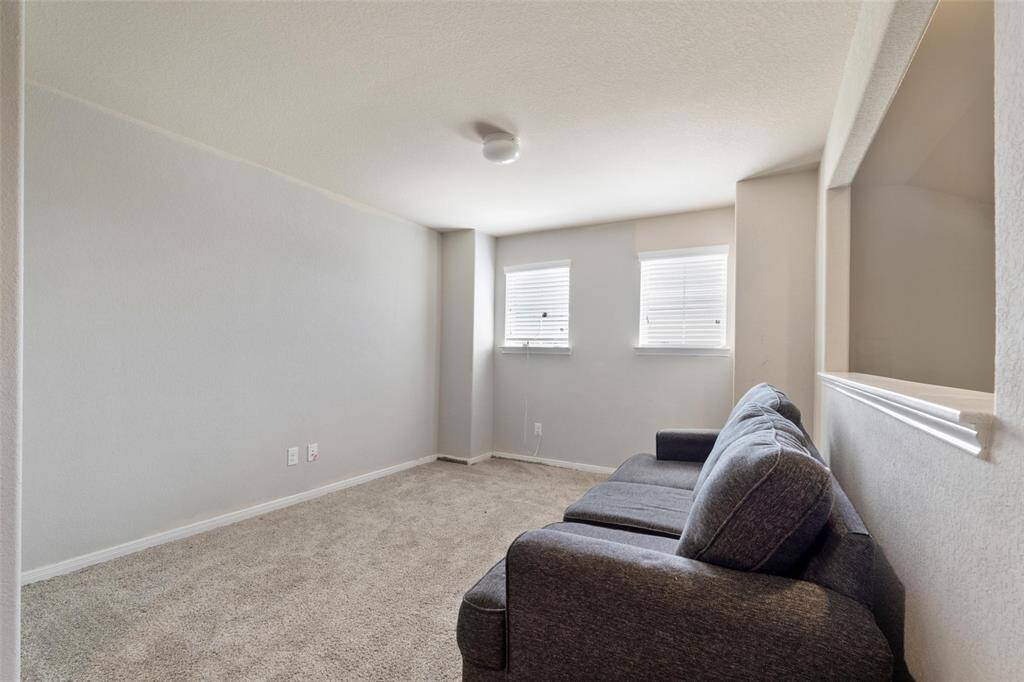 Cozy upstairs flex space with carpet and natural light from dual windows. Perfectly suited for a game room, media nook, play area, or home office.