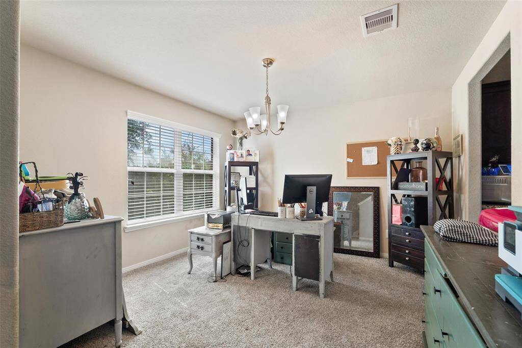 Versatile formal dining room or flex space with a large front-facing window for natural light.