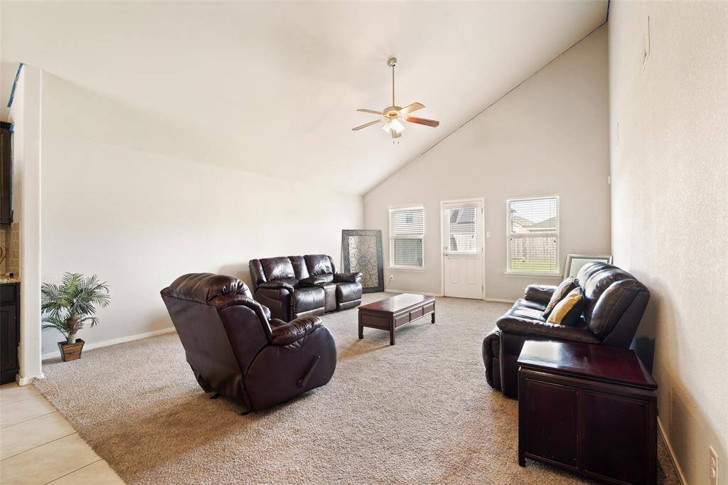 Bright and spacious living room feauting vaulted ceilings with an abundant natural light from large windows.