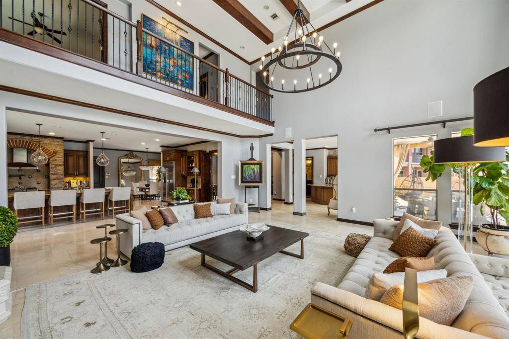 Take note of the room’s stunning focal point—soaring double-height ceilings that lend a modern touch to this bright and inviting living area overlooking the backyard oasis. A beautifully crafted stone fireplace with gas logs elevates the ambiance, adding warmth and sophistication.