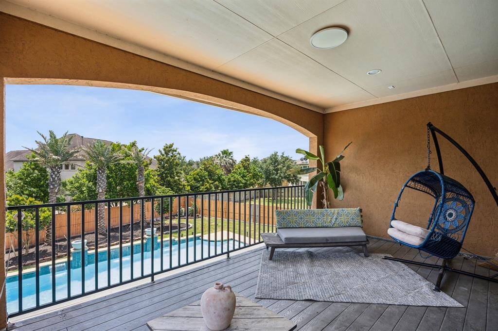 The rich double doors open to the Balcony overlooking the Backyard Oasis.
