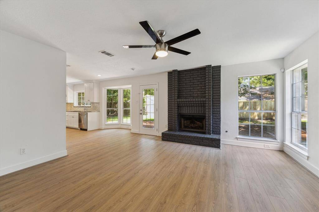 View of the family room, all the windows, the natural light, freshly painted fireplace. A white canvas for you to turn it into your own space.