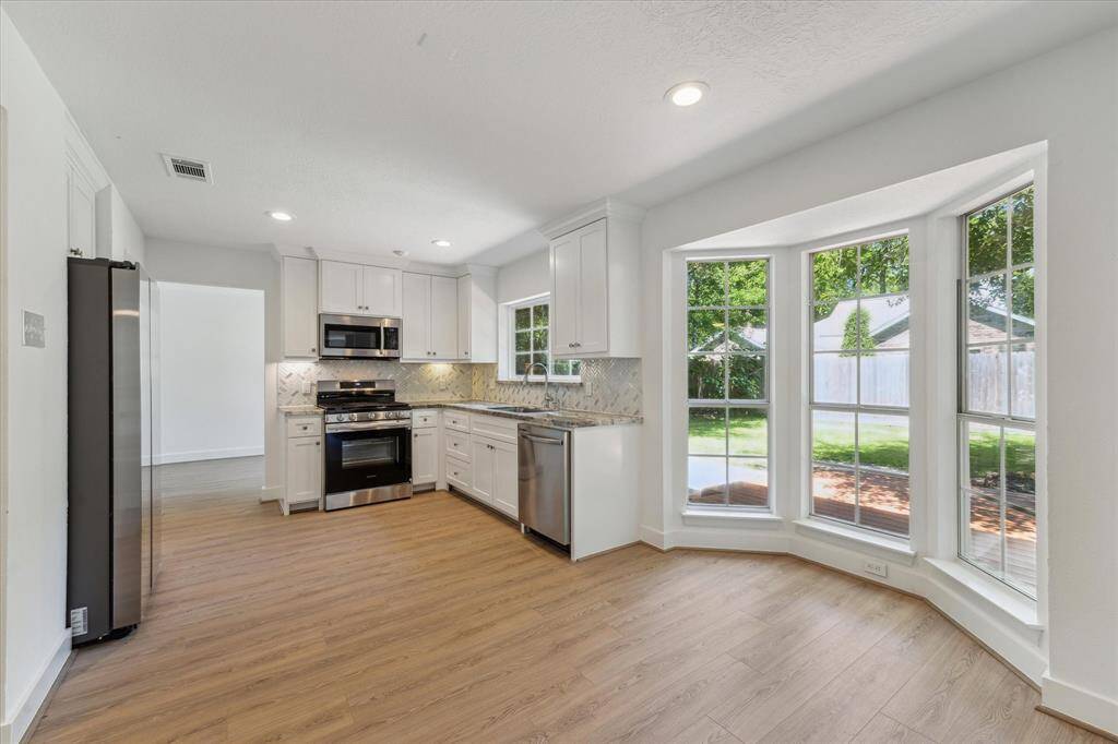 A view from the family room to the kitchen and breakfast area, the new deck and backyard.