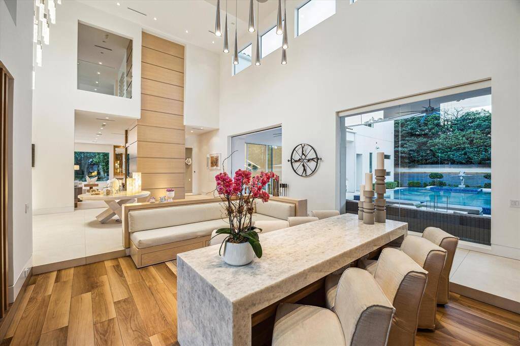 Lounge / Wet Bar with its soaring ceilings and elegant proportions, features a concealed wet bar behind custom cabinetry, an ideal setting for gracious entertaining and welcoming guests in style.