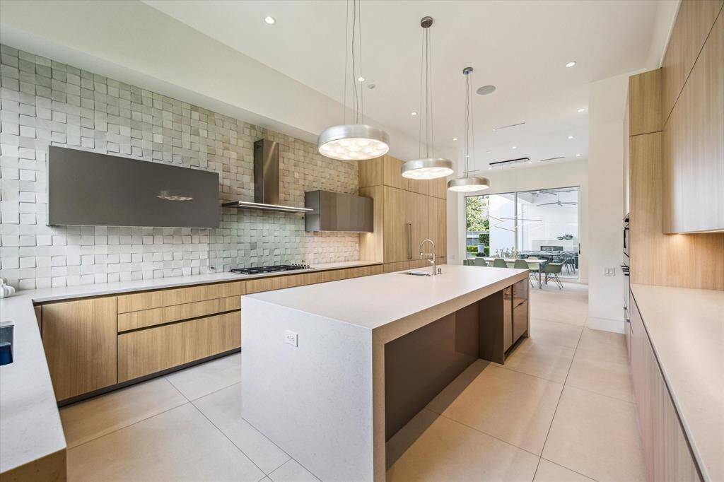 The kitchen is equipped with state of the art Miele appliances, including a full-sized refrigerator and freezer seamlessly integrated with custom cabinet façades, a built-in stainless steel coffee machine, stainless steel microwave, and dual stainless steel convection ovens; offering both elegance and exceptional performance for the culinary enthusiast.