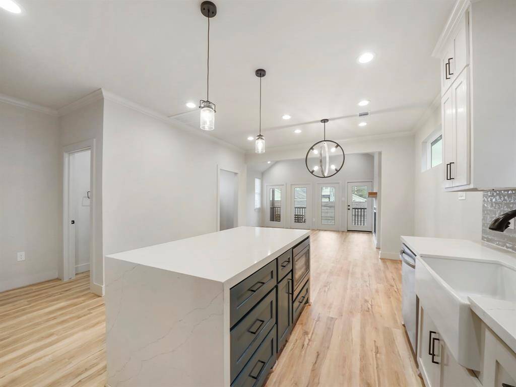 Plenty of storage available in the waterfall isalnd with microwave.  Sleek ceramic apron front sink and modern lighting and fixtures.