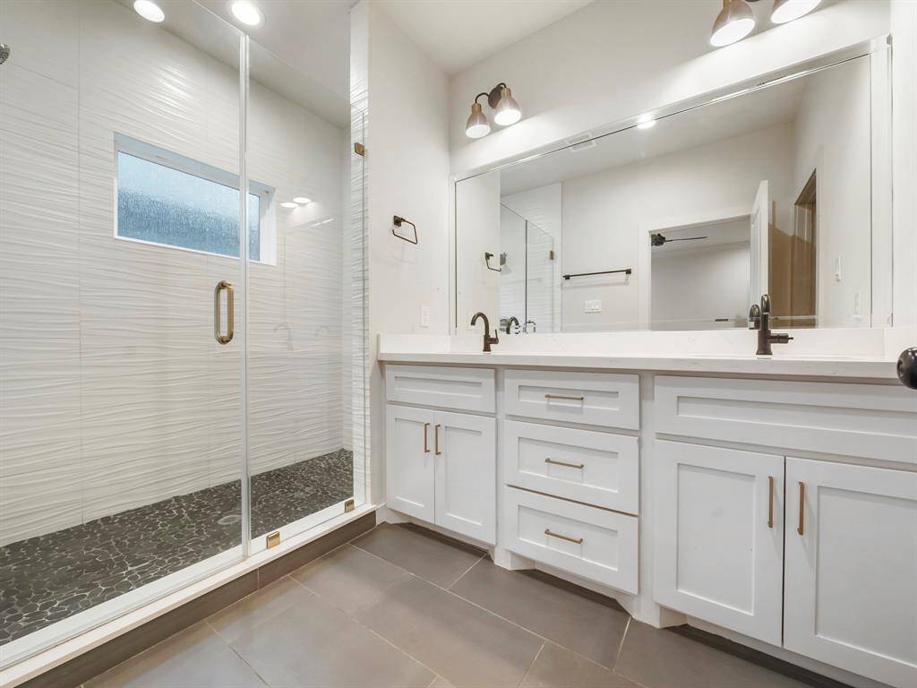 Welcome to your luxurious primary ensuite bathroom! This elegant space features double vanity sinks, offering ample room for you to prepare for the day ahead with ease and style. But the centerpiece of this oasis is the oversized walk-in shower, where you can indulge in spa-like relaxation every day. Welcome to a space where luxury meets functionality, ensuring that every morning begins with a touch of indulgence and comfort.