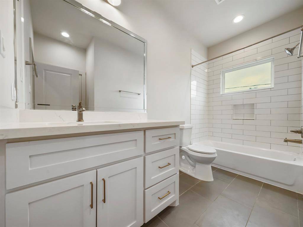 Secondary jack and jill bathroom with shower/tub combo.