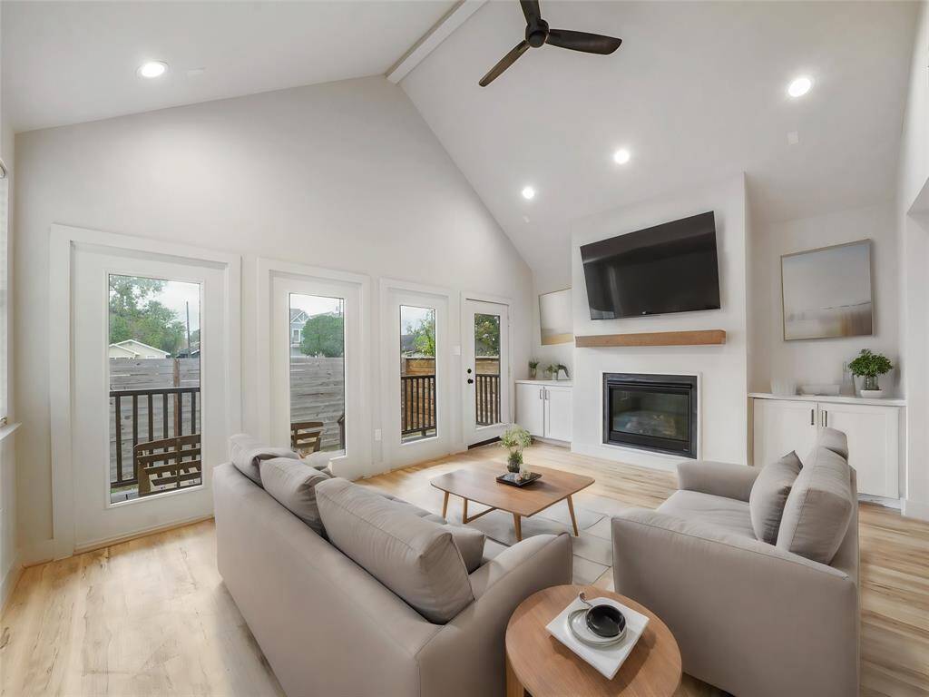 Step into your inviting living room retreat! With a vaulted ceiling adding grandeur, a cozy fireplace with a mantle, and custom cabinetry providing both style and storage, this space is perfect for relaxation. Large windows offer views of the serene back porch, creating a tranquil atmosphere for unwinding and making memories. photo is virtually staged.